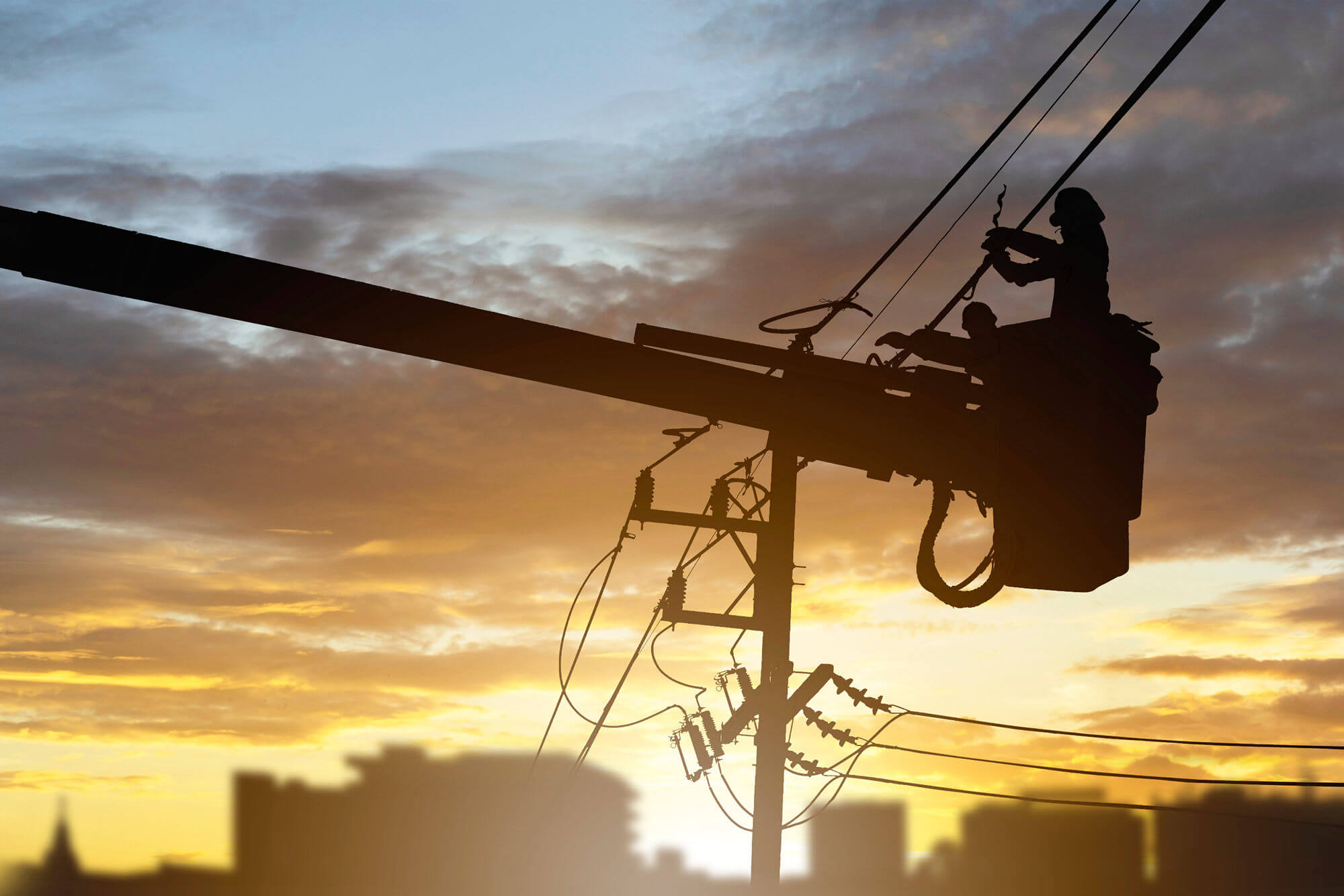 Electricians working on high voltage wires from a lift bucket